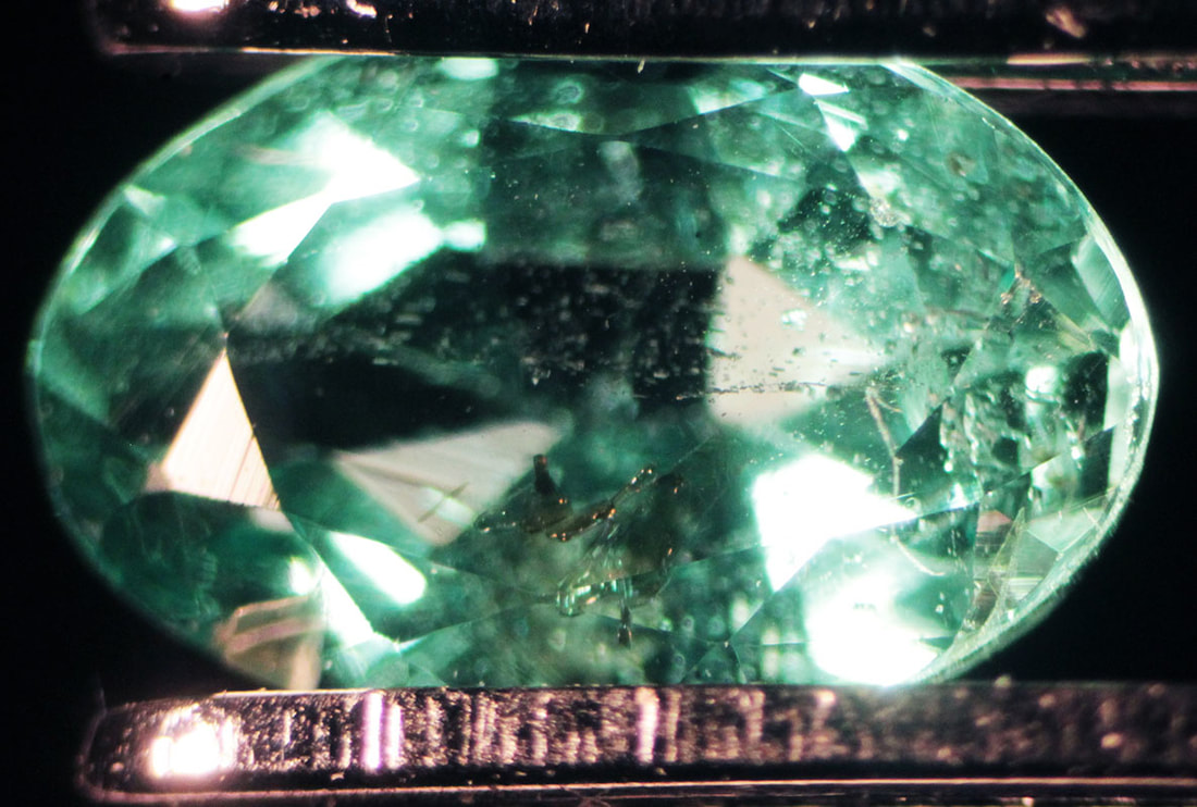 Smeraldo osservato al microscopio che ha subito in alcune aree delle infiltrazioni